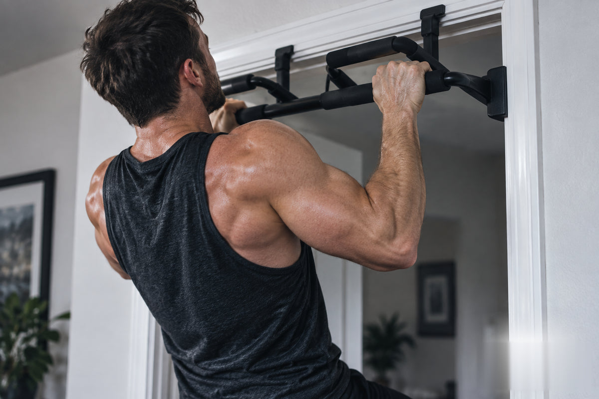 Athlete performing a strict pull-up on a doorway pull-up bar